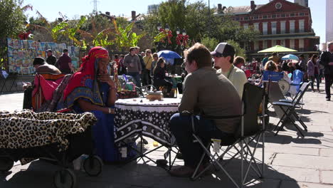 Tarot-card-reader-with-two-clients-on-a-busy-New-Orleans-square