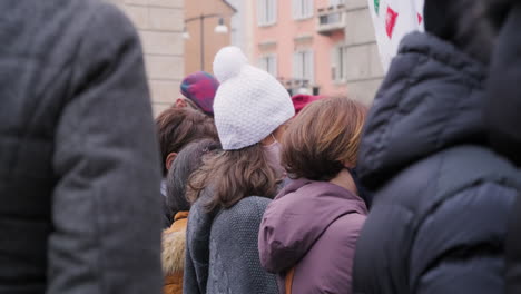 Italian-Woman-Wearing-Mask-And-Beanie-Winter-Hat-In-The-Crowd-During-Coronavirus-Protest-In-Milan,-Italy