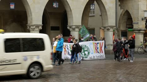 Small-group-of-young-protesters-demonstrating-outdoors-in-city-for-climate-during-covid-19-epidemic---Wide-shot