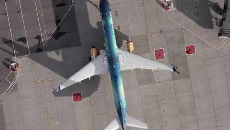 Top-down-aerial-above-Icelandair-Boeing-757-with-colorful-fuselage,-Hekla-Aurora