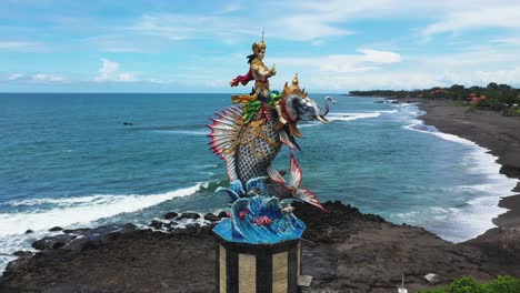 God-of-Baruna-Statue-riding-Mina-Elephant-at-Pererenan-beach,-Aerial-Orbit-around-shot