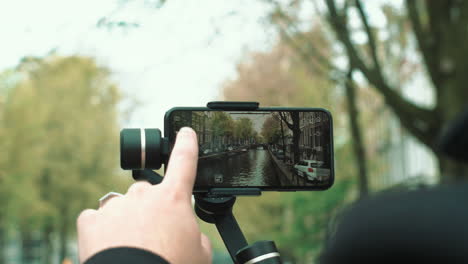 A-man-that-starts-to-film-the-Amsterdam-canals-on-his-phone-with-a-gimbal