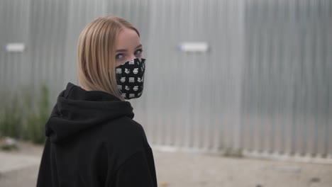 Slow-Motion,-Blonde-Girl-With-Face-Mask-and-Hoodie-Looking-at-Camera