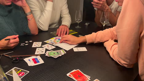 Family-playing-mystery-game-named-Exit-indoors-on-black-table