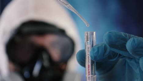 Biologist-protected-by-coverall-and-goggles-fills-test-tube-with-covid-19-antidote