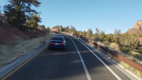 Tracking-shot-of-BMW-M3-drive-on-empty-road-through-Arizona-wilderness