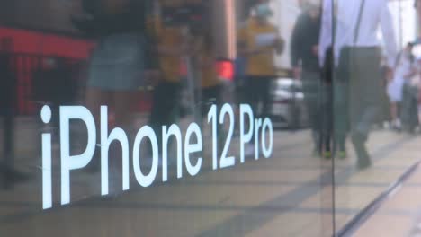 Reflection-of-pedestrians-seen-walking-past-an-Apple-store-with-its-window-displays-the-new-iPhone-12-Pro-during-the-launch-day-of-the-new-iPhone-12-and-iPhone-12-Pro-phones