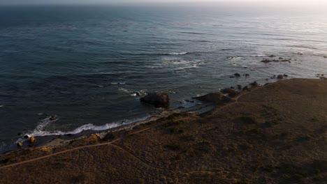 Drone-cinematic-orbit-shot-of-Pacific-Ocean-coast-and-rocks-in-Big-Sur,-California
