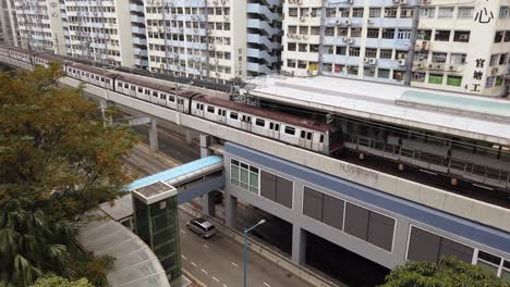 Hong-Kong-downtown-MTR-city-tram-crossing-a-bridge,-Aerial-view