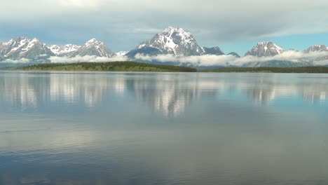 Morning-view-of-a-very-calm-Jackson-Lake-in-Grand-Teton-National-Park-with-the-Tetons-in-the-background-and-very-low-clouds