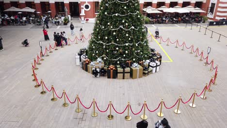 People-viewing-a-Large-Christmas-tree-in-Hong-Kong-Former-Central-Police-Station-Compound-with-people-passing-by