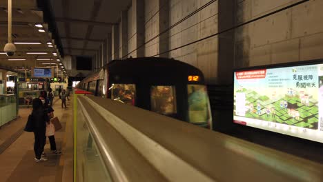 Tren-Subterráneo-De-Hong-Kong-Mtr-Llegando-A-La-Estación,-Con-Embarque-De-Pasajeros