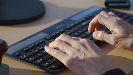 Close-shot-of-the-hands-of-a-man-typing-on-a-computer-keyboard