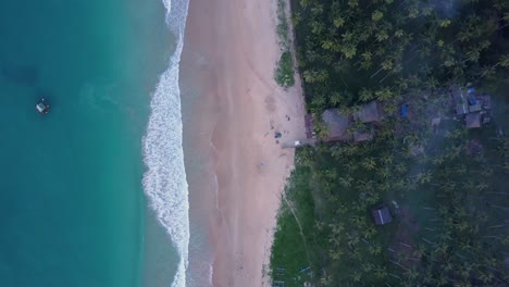 Aerial-tracking-shot-of-turquoise-waters,-empty-beach-and-palm-trees-at-Nacpan-Beach-near-El-Nido-on-Palawan,-the-Philippines