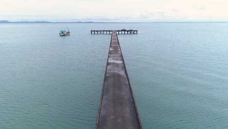 Drone-shot-of-a-pier-leading-into-the-sea