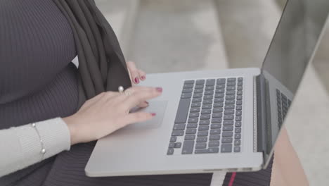 Close-Up-Shot-Of-Woman-Typing-On-Laptop-Keyboard-Whilst-Sat-Outside---Ungraded
