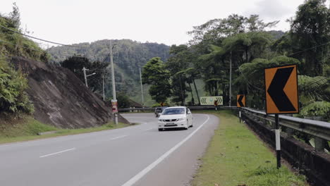 White-car-driving-uphill-windy-road-in-Cameron-Highlands-Malaysia