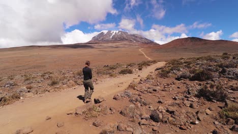 Static-shot-of-a-woman-hiking,-towards-the-summit-of-mount-Kilimanjaro,-on-a-sunny-day,-near-Horombo-hut,-in-Tanzania,-Africa
