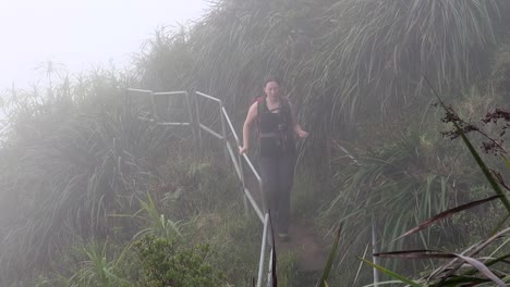 Young-woman-walks-through-cloud,-high-on-the-Haiku-Stairs