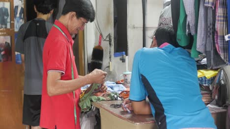 Alte-Indonesische-Schneidernähen---Messen-Von-Stoffen-Für-Die-Herstellung-Bunter-Hemden-Im-örtlichen-Geschäft