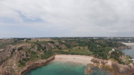 High-drone-aerial-footage-of-Beauport-Beach-and-the-surrounding-scenery-in-Jersey