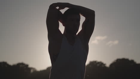 Man-Stretches-Before-He-Works-Out-Whilst-Being-Silhouetted-By-The-Evening-Sun-In-Slow-Motion---Ungraded