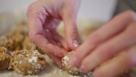 Close-up-dolly-of-woman's-hand-pushing-down-on-raw-cookie-dough