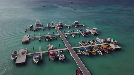 Boats-at-a-dock-in-the-beautiful-blue-Caribbean-Sea-in-Palm-Beach,-Aruba