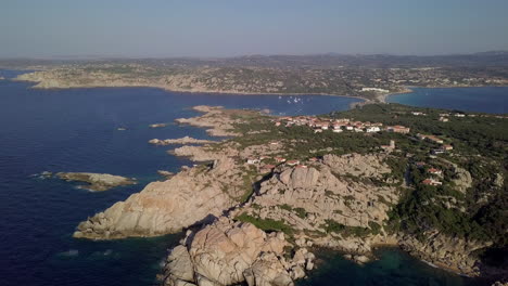 Drone-shot-flying-over-a-wild-and-rocky-coastline-towards-a-pristine-bay-in-north-Sardinia