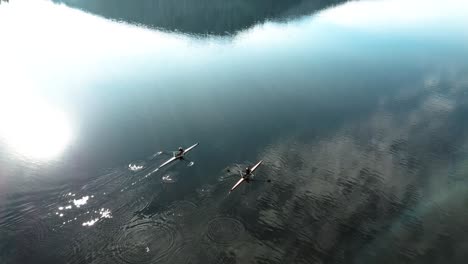 4K-low-drone-shot-over-winter-lake-in-French-mountains
with-two-kayaks-paddling-in-the-sun