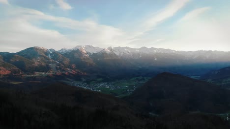 Aerial-of-sunset-over-alps-in-italy-with-snowy-mountains-and-green-valley