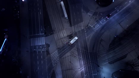 Vertikale-Nachtansicht-Aus-Der-Luft,-Verkehrsautos-Auf-Der-Kreuzung-Und-Straßenlaternen-Und-Beleuchtete-Straßen-In-Einer-Modernen-Stadt
