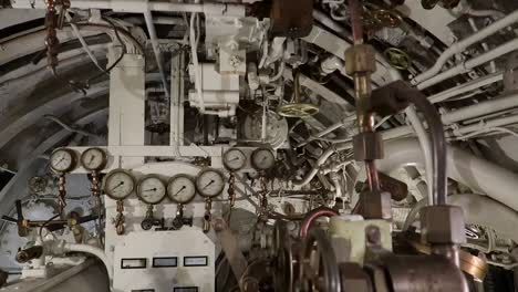elements-inside-an-old-submarine's-command-control-room,-sliding-shot