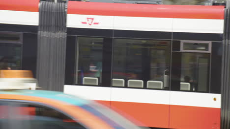 4K-footage-of-streetcars,-cars,-bikes,-and-pedestrians-traveling-along-Spadina-Avenue-in-Chinatown,-downtown-Toronto,-Canada