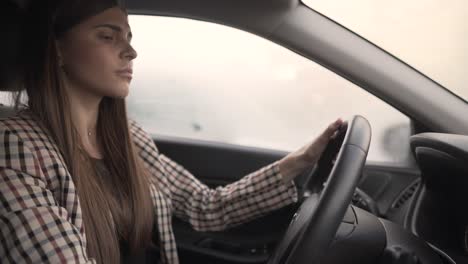Beautiful-young-woman-is-going-to-drive-a-car-but-something-is-going-wrong-and-she-isn't-able-to-start-the-car