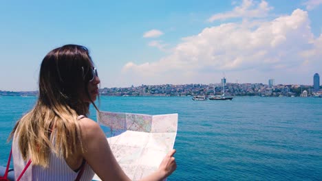 Slow-motion:Beautiful-girl-looks-map-of-Istanbul-with-view-of-Bosphorus,a-popular-destination-in-Uskudar,Istanbul,Turkey