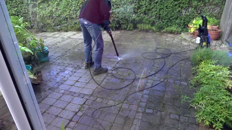 Person-washing-garden-stones-with-a-high-pressure-wash
