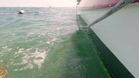 Grünes-Wasser-Plätschert-Vor-Einem-Weiß-roten-Boot-Auf-Dem-Meer