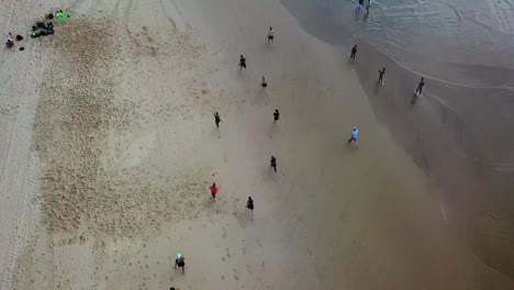 Aerial-top-down-view-of-people-sprinting-on-the-beach