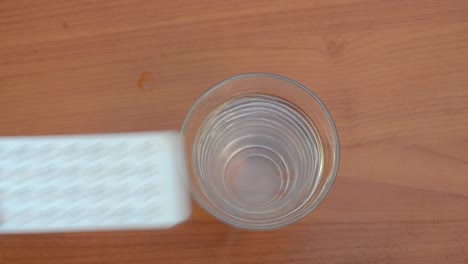 Frau-Legt-Verhütungspillen-über-Das-Glas-Wasser