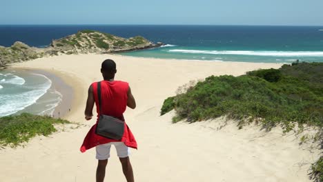Young-guy-looking-out-at-Robberg-Beach,-Plettenberg-bay