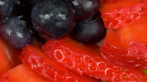 Makroaufnahme-Einiger-Rotierender-Glasierter-Blaubeeren-Und-Geschnittener-Erdbeeren