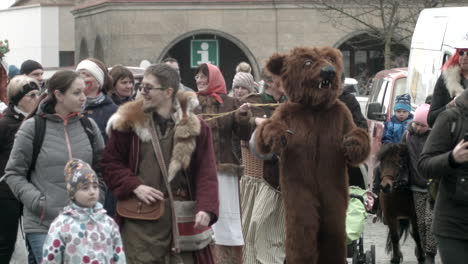 A-person-dressed-in-a-dancing-bear-costume-is-guided-throught-the-crowd-at-Masopust-in-Czech-Republic