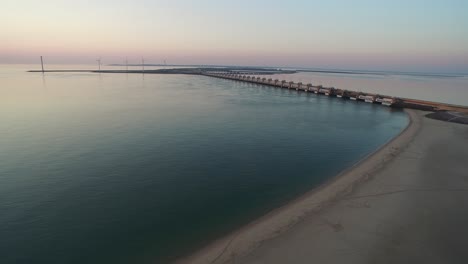 Aerial:-The-beach-around-the-Oosterschelde-storm-surge-barrier-during-a-summer-sunset