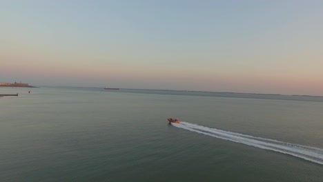 Aerial:-Following-a-rescue-boat-at-full-speed,-passing-by-Vlissingen,-the-Netherlands