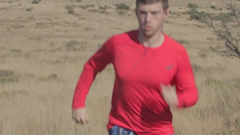 Man-running-uphill-on-a-trail-in-a-dry-field