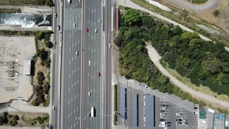 Top-down-pan-up-view-of-highway-traffic-on-101-roof-top-solar-panels-pan-handle-garden-moving-hold
