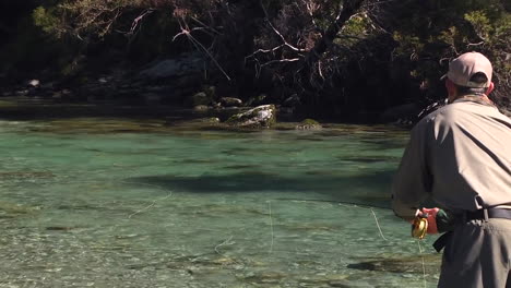 Trout-fly-fishing-in-mountain-river-at-summer