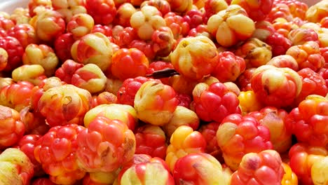 Group-of-fresh-cloudberries,-hand-picking-up-one,-real-time