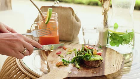 Una-Mujer-Almorzando-Corta-Un-Sándwich-Verde-Y-Saludable-En-La-Cafetería